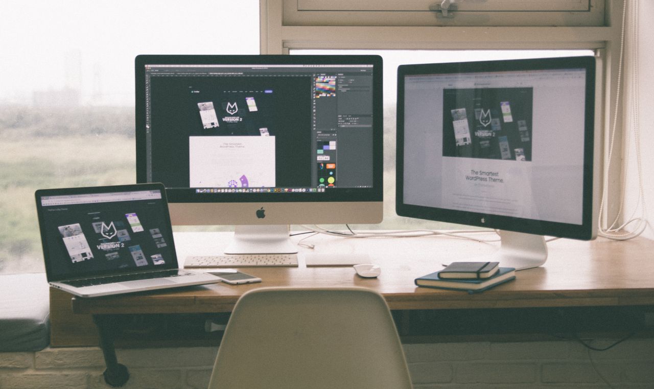 Services-03 Stylish and efficient workspace with multiple monitors, laptop, and smartphone, showcasing a web design project.